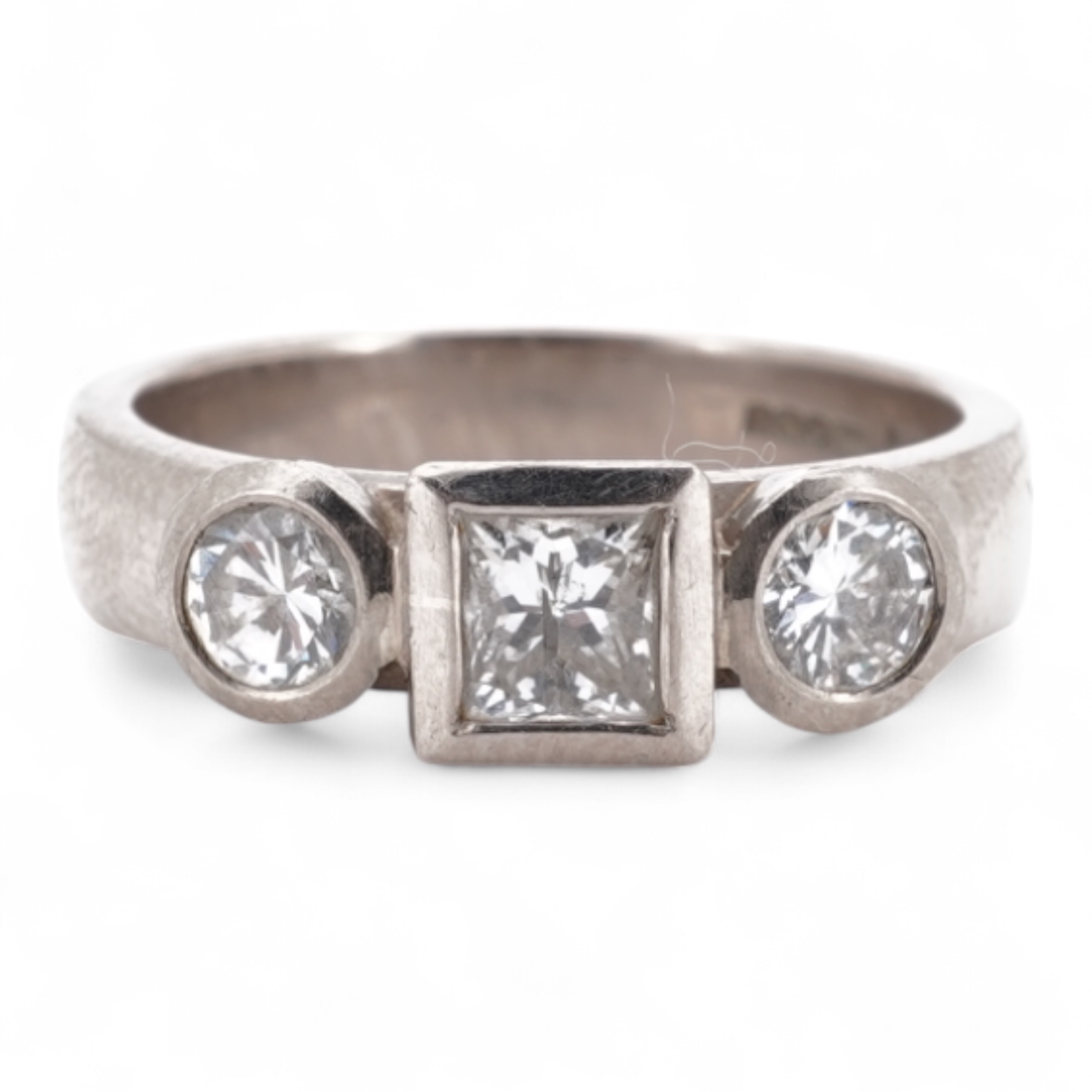 A modern 18ct white gold and three stone diamond ring, set with single square cut diamond and two round cut diamonds, size K, gross weight 5.8 grams.